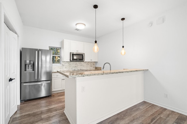 kitchen with kitchen peninsula, decorative backsplash, appliances with stainless steel finishes, light stone counters, and white cabinetry