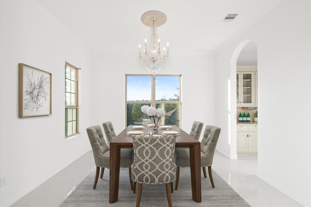 dining space with an inviting chandelier and ornamental molding