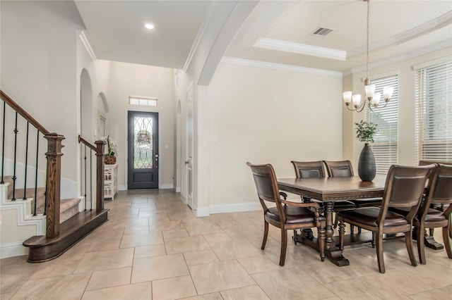 tiled dining room featuring a notable chandelier and ornamental molding