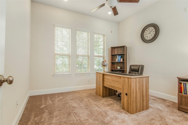 carpeted home office featuring ceiling fan