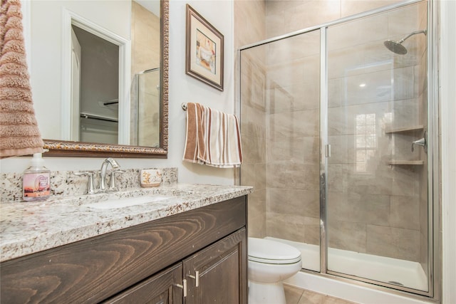 bathroom featuring tile patterned floors, vanity, toilet, and an enclosed shower