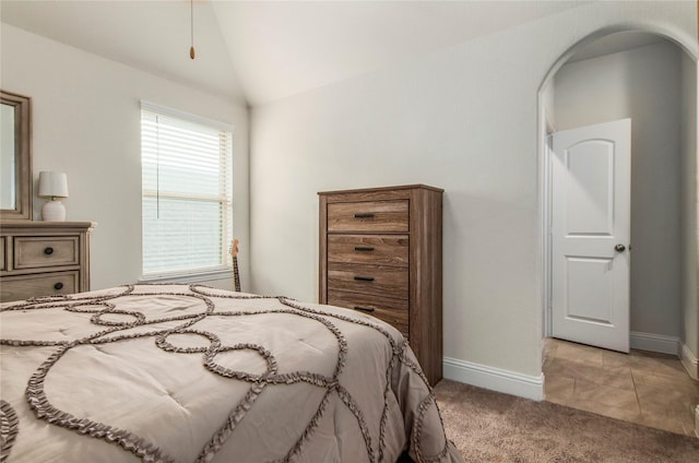 bedroom featuring light colored carpet and vaulted ceiling