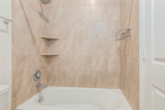 bathroom with toilet and tiled shower / bath