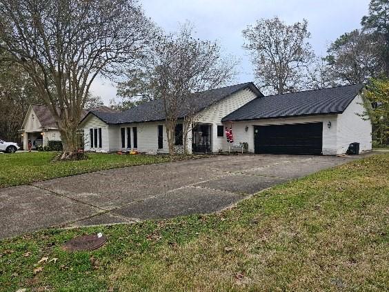 ranch-style house featuring a garage and a front yard