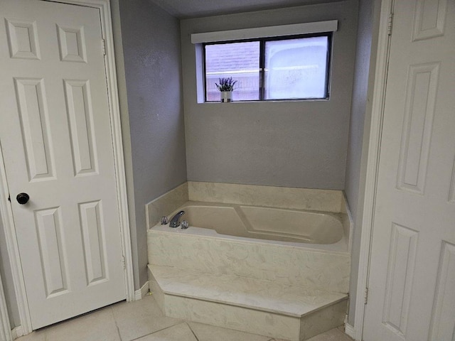 bathroom with tile patterned floors and a bath