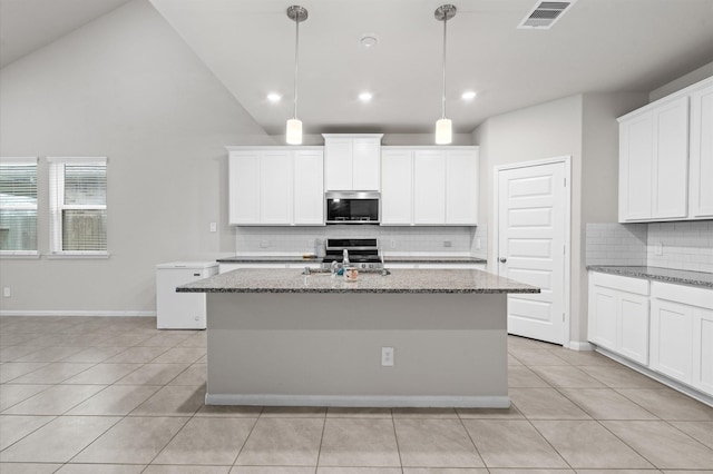 kitchen with pendant lighting, light tile patterned floors, a kitchen island with sink, and high vaulted ceiling