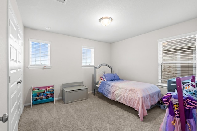 carpeted bedroom with multiple windows