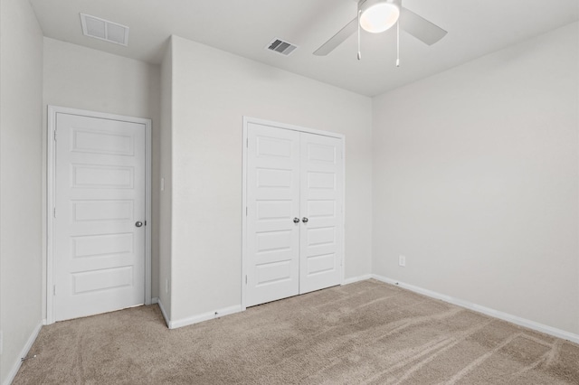 unfurnished bedroom with ceiling fan, a closet, and carpet