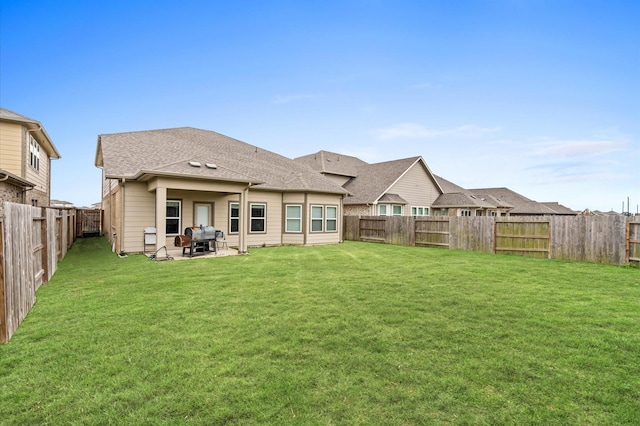 rear view of property featuring a patio area and a lawn