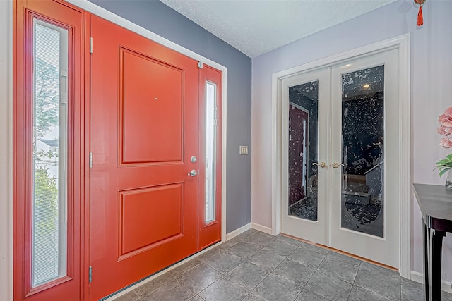 foyer entrance with french doors and a textured ceiling