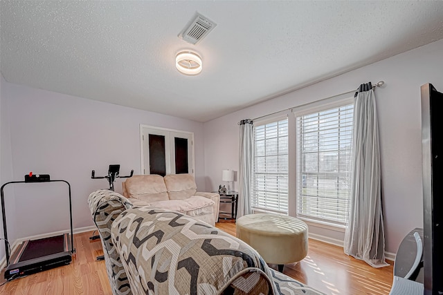 living room with a textured ceiling and light hardwood / wood-style flooring