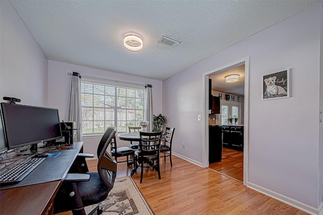 office space featuring light hardwood / wood-style flooring and a textured ceiling