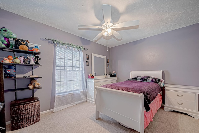 carpeted bedroom with ceiling fan and a textured ceiling