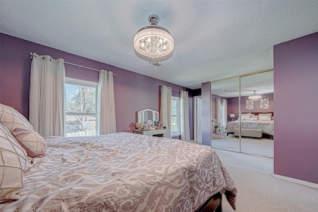 carpeted bedroom with a textured ceiling and a closet