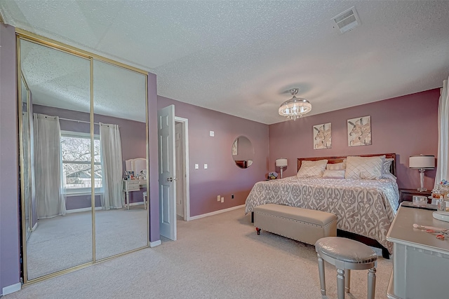 carpeted bedroom featuring ceiling fan with notable chandelier, a textured ceiling, and a closet