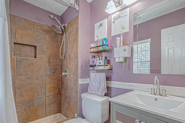 bathroom featuring walk in shower, vanity, a textured ceiling, and toilet