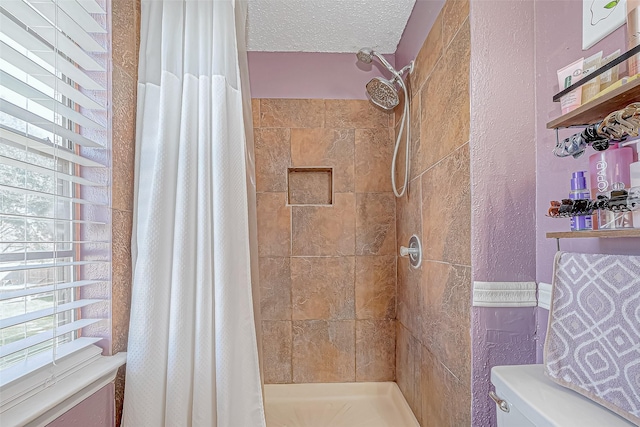 bathroom with curtained shower, toilet, and a textured ceiling