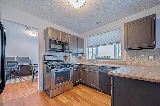 kitchen with decorative backsplash, sink, black appliances, and light wood-type flooring