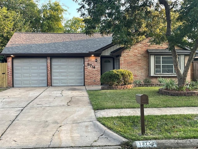 ranch-style home with a garage and a front lawn