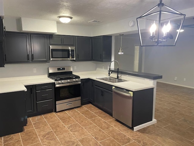 kitchen with sink, hanging light fixtures, a notable chandelier, kitchen peninsula, and appliances with stainless steel finishes