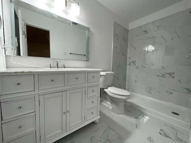 bathroom featuring tiled shower, vanity, and toilet