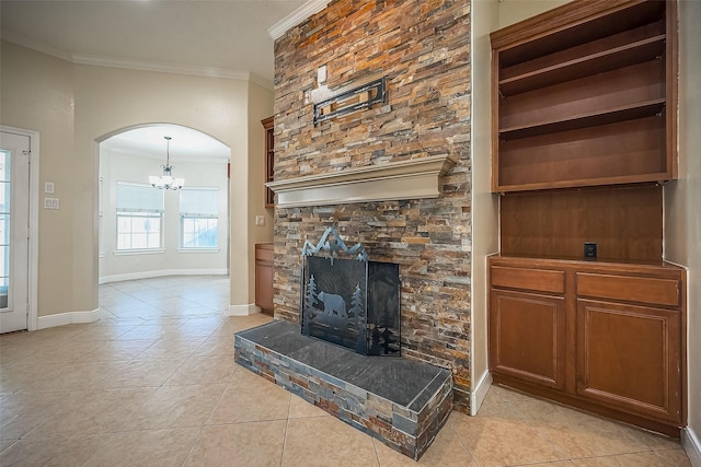 tiled living room with a notable chandelier, ornamental molding, and a fireplace