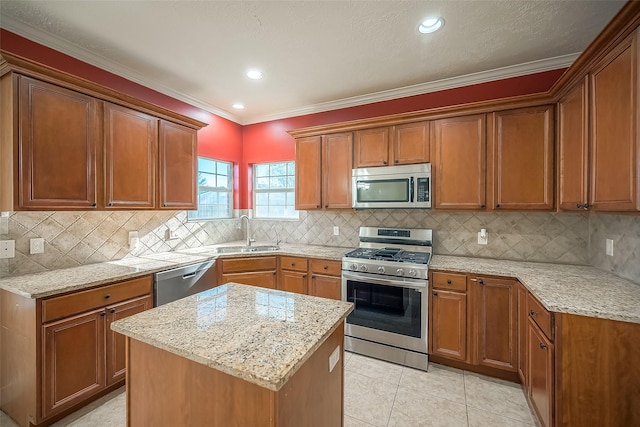 3815 Founders Dr, Needville, TX 77461 - kitchen featuring appliances with stainless steel finishes, light stone counters, brown cabinets, decorative backsplash, and ornamental molding
