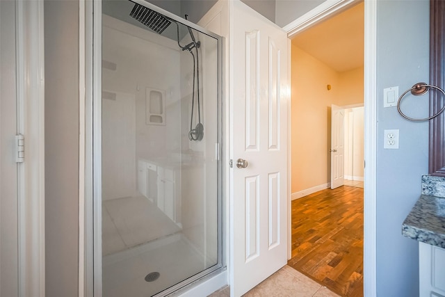 bathroom with tile patterned floors and a shower with door