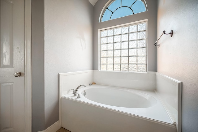 bathroom featuring a bathing tub and vaulted ceiling