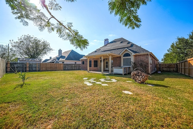 3815 Founders Dr, Needville, TX 77461 - rear view of property with solar panels, brick siding, a fenced backyard, a patio, and a chimney