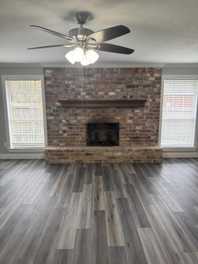 unfurnished living room featuring a wealth of natural light, a fireplace, ceiling fan, and a textured ceiling