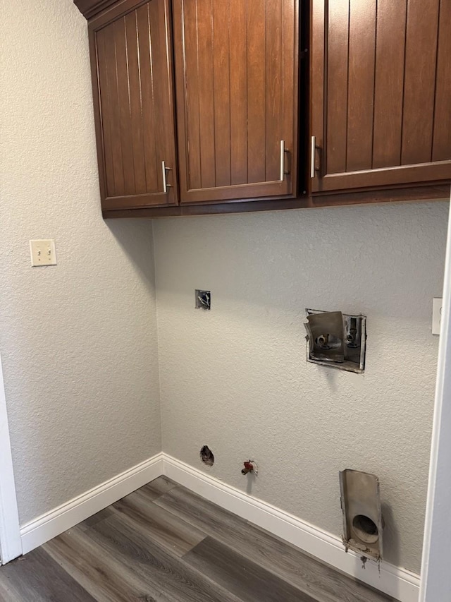 clothes washing area featuring cabinets, hookup for a washing machine, hookup for a gas dryer, and dark wood-type flooring