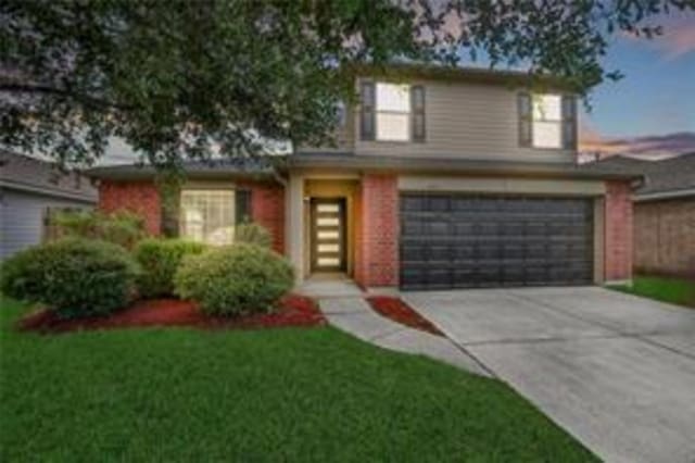 view of property featuring a yard and a garage