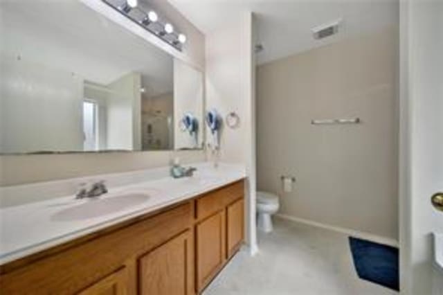 bathroom with vanity, toilet, and a shower