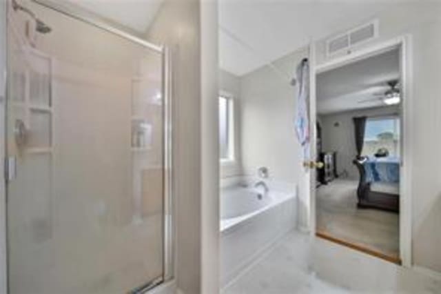 bathroom with ceiling fan and plus walk in shower