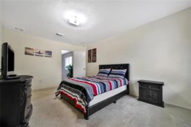 bedroom featuring light carpet