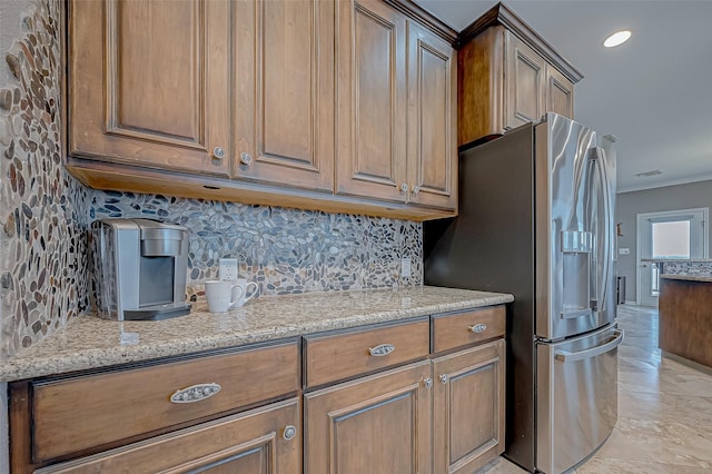 kitchen with backsplash, light stone counters, light tile patterned floors, and stainless steel refrigerator with ice dispenser