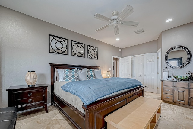 bedroom with ceiling fan, sink, and a closet