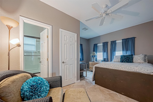 tiled bedroom featuring ensuite bath and ceiling fan