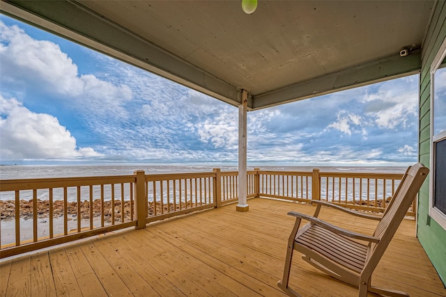 deck featuring a view of the beach and a water view