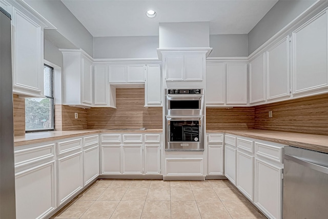 kitchen with white cabinets, light tile patterned floors, and appliances with stainless steel finishes