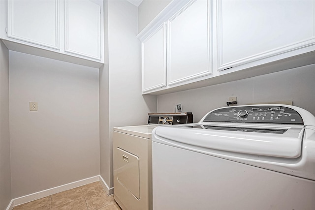 laundry room featuring cabinets, independent washer and dryer, and light tile patterned floors