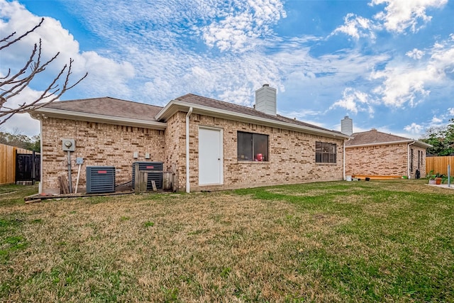 rear view of house with a yard and central air condition unit