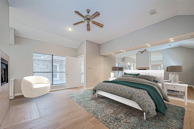 bedroom with ceiling fan, light hardwood / wood-style flooring, and lofted ceiling