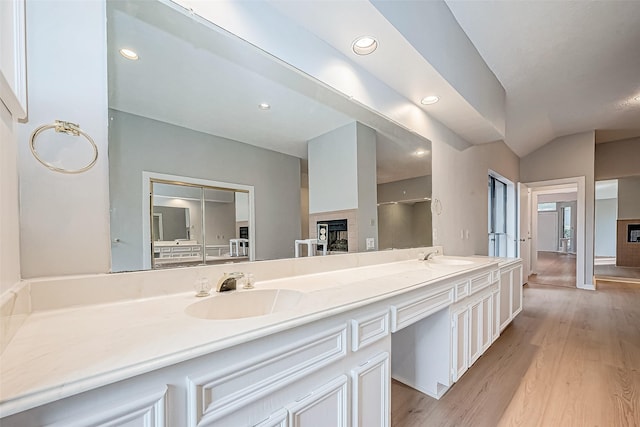 bathroom with vanity, vaulted ceiling, and hardwood / wood-style flooring