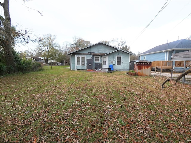 back of property featuring a yard and a shed