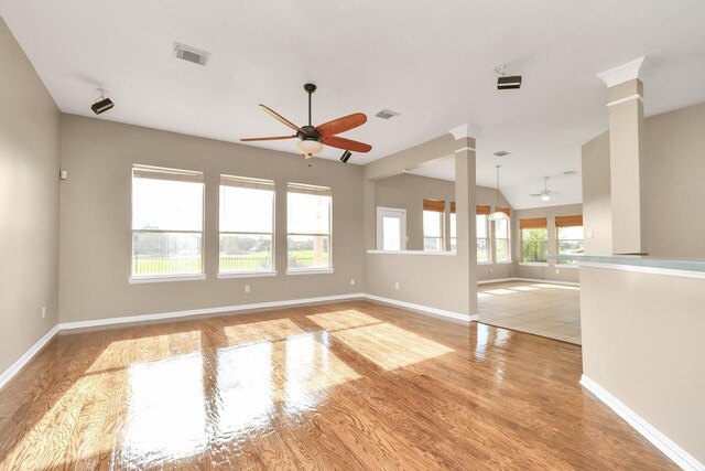 unfurnished room with ornate columns, ceiling fan, and light hardwood / wood-style flooring