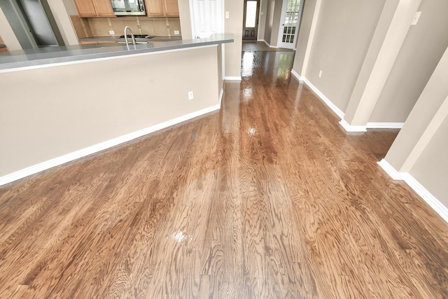 kitchen with light brown cabinets, sink, tasteful backsplash, and wood-type flooring