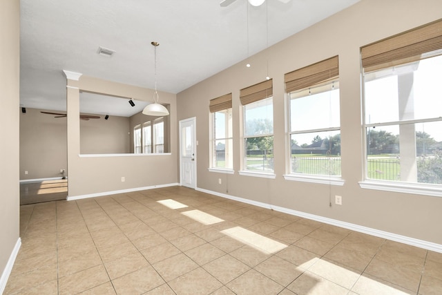 tiled spare room featuring ceiling fan