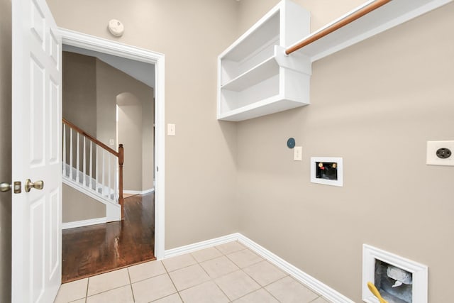 laundry area with electric dryer hookup, hookup for a washing machine, and light tile patterned floors